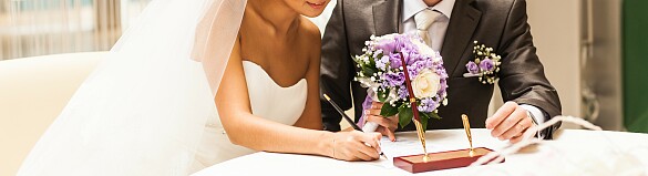Ein Hochzeitspaar, das ein Dokument unterschreibt