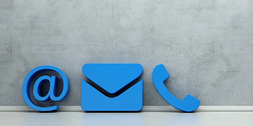 Symbole für Telefon, Brief und E-Mail lehnen an einer Wand