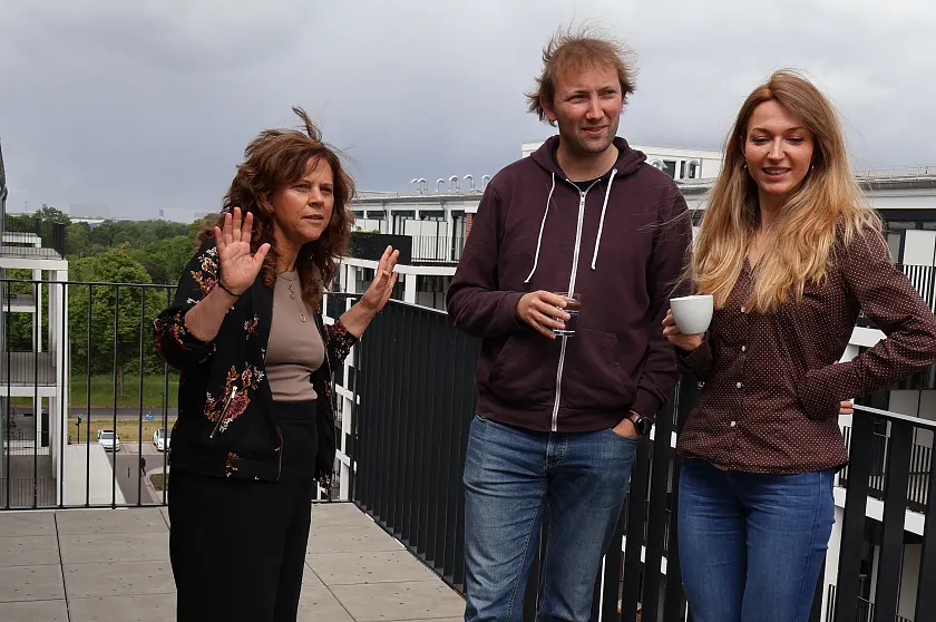 Zwei Frauen und ein Mann stehen auf dem Balkon