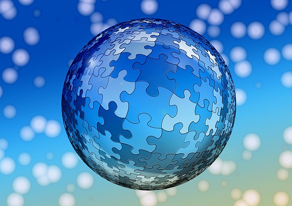 Eine Kugel geformt aus blauen Puzzleteilen vor einem blauen Hintergrund mit weißen Lichtreflexen