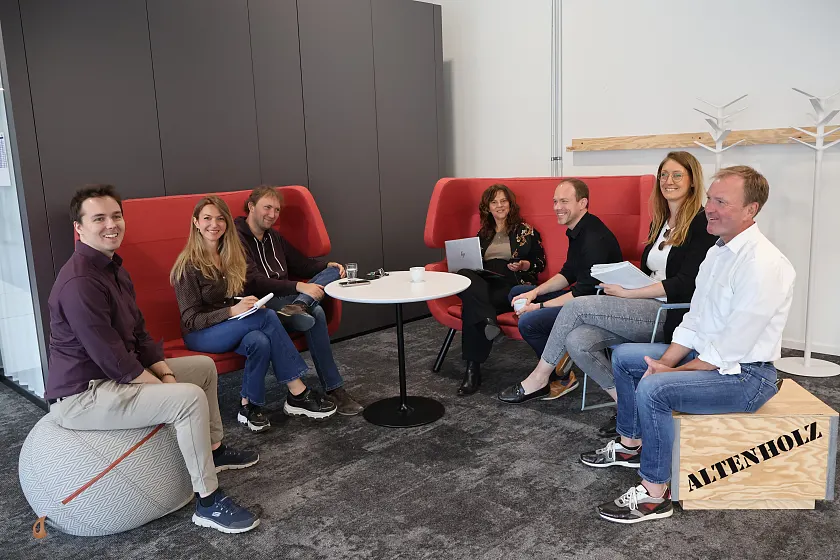 Die Mitarbeitenden des Digitalisierungsb&uuml;ro sitzen im Kreis auf Sofas