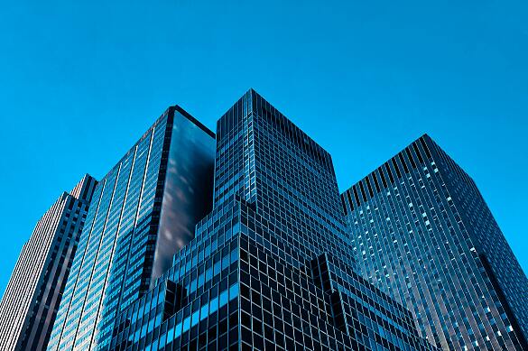 Froschperspektive auf Hochhäuser vor blauem Himmel