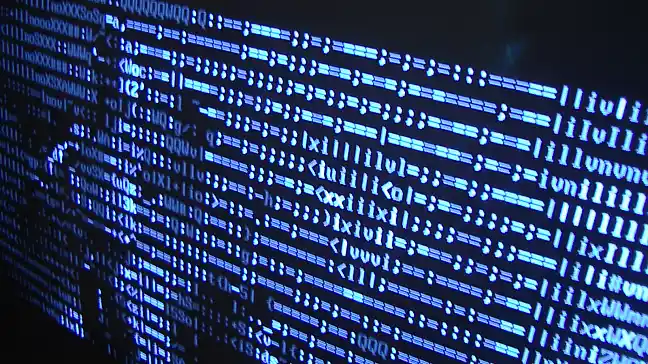 Zeichenfolge wie auf einem Monitor, im Hintergund erahnt man die Konturen von einer Person