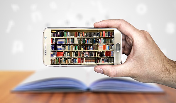Eine Hand hält eine Smartphone auf dessen Bildschirm ein Regal mit Büchern zu sehen ist