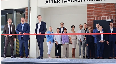 Senator Fecker durchtrennt das rote Band zur Eröffnung des Tabakquartiers