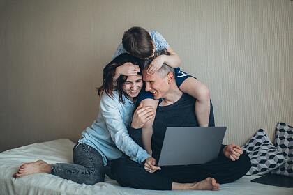 Eine lachende Familie vor einem Computer
